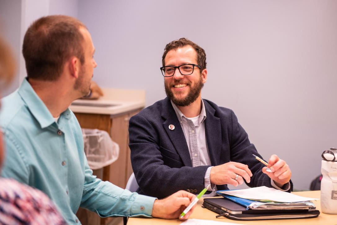 Two male students chat during a class.