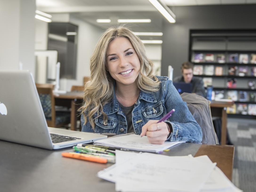 Student studying her class notes on her laptop.