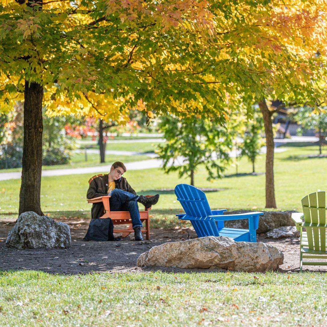 Student studying his class notes outdoors.